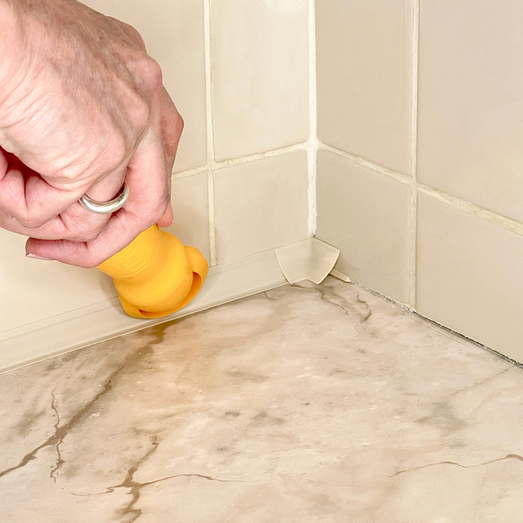 Close-up of the same tiled corner countertop with ivory InstaTrim neatly applied along the seams.